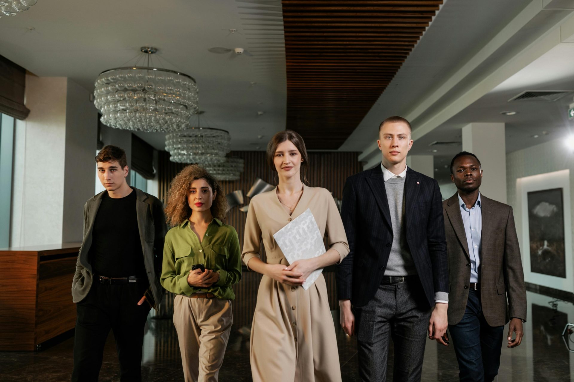 A diverse group of professionals confidently walking through a stylish office environment.